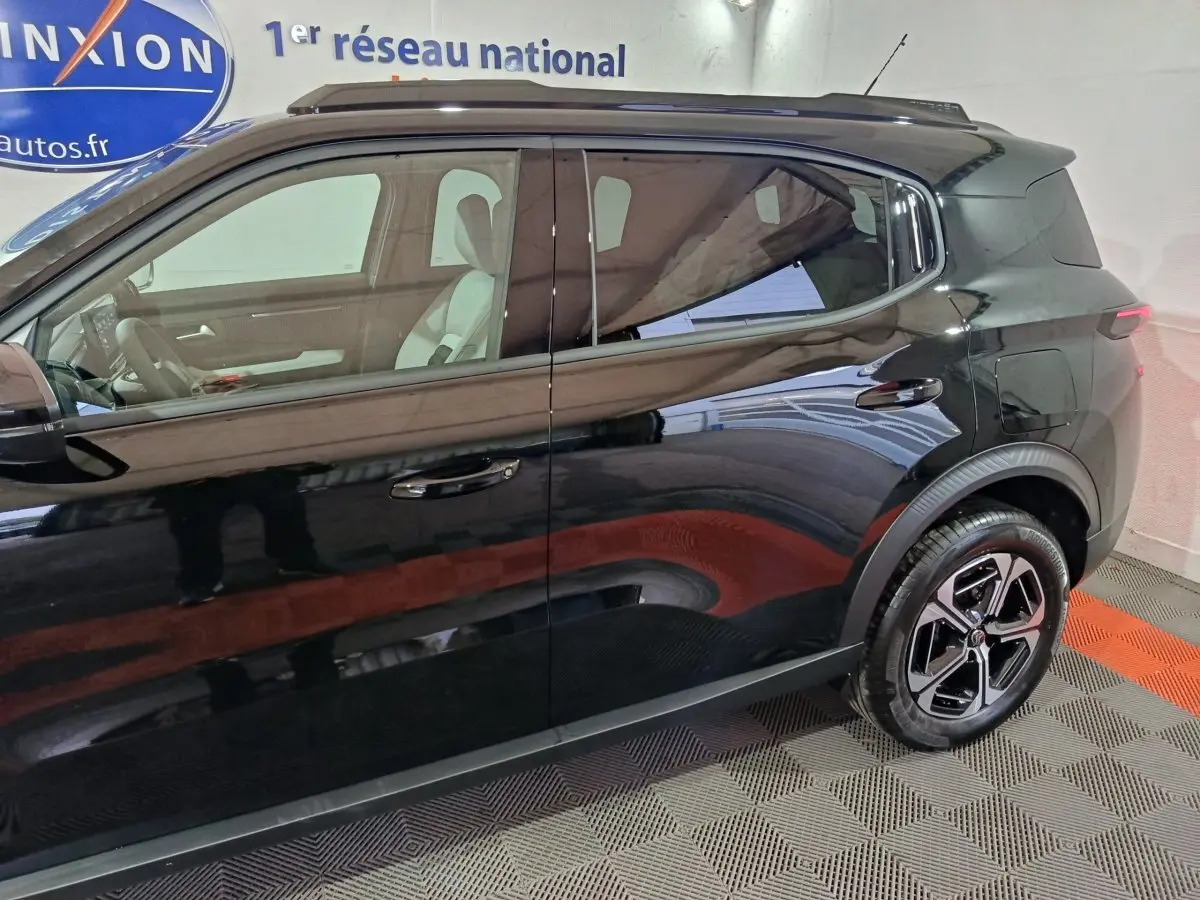 Vue latérale gauche d'une Citroën C3 hybride noire 2025, mettant en valeur ses jantes et la ligne de toit compacte.