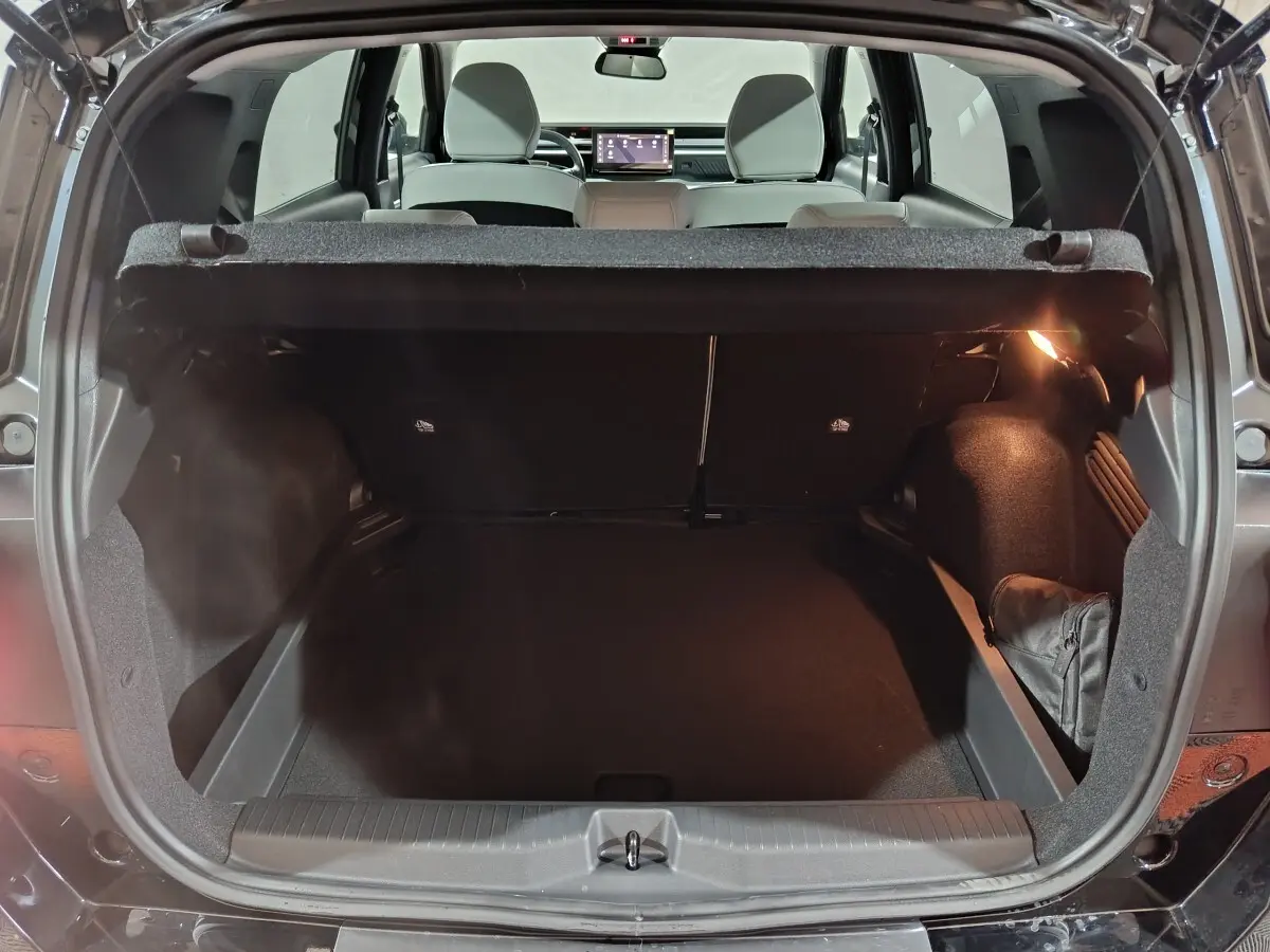 Coffre ouvert vu de l'arrière d'une Citroën C3 noire hybride 2025, intérieur spacieux et banquette arrière visible.