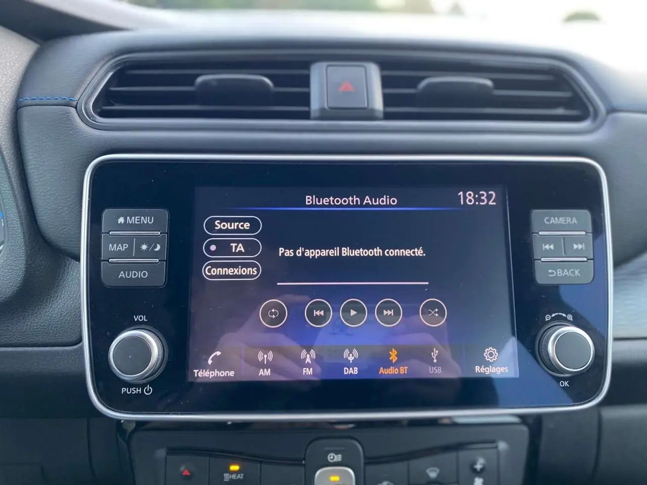 Vue rapprochée de l’écran tactile central du tableau de bord du Nissan Leaf blanc 2020, affichant la connexion Bluetooth audio.