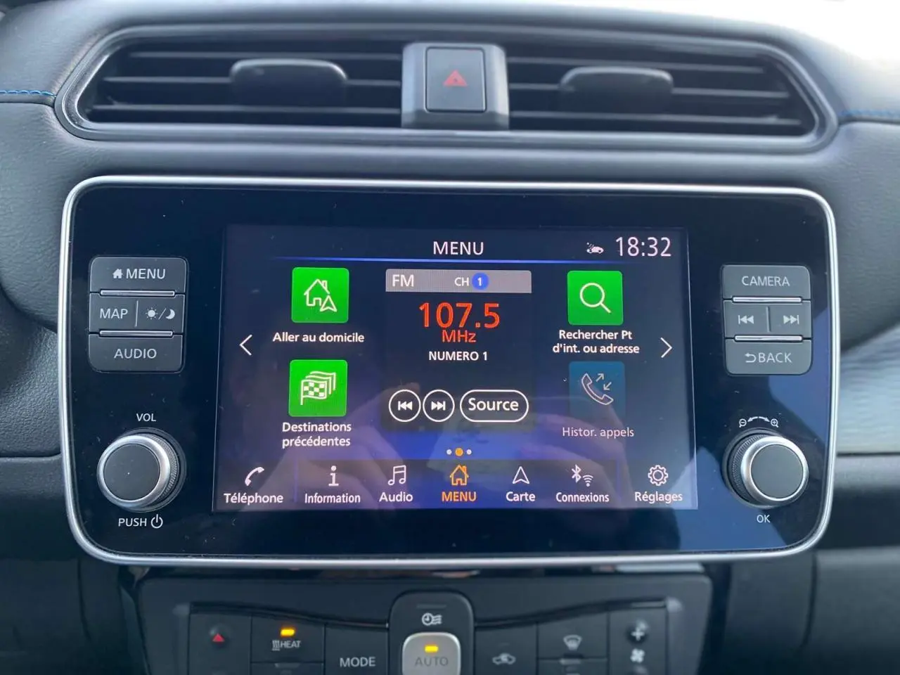 Écran tactile central du tableau de bord de la Nissan Leaf 40 kWh blanc, affichant le menu radio FM à 18h32.