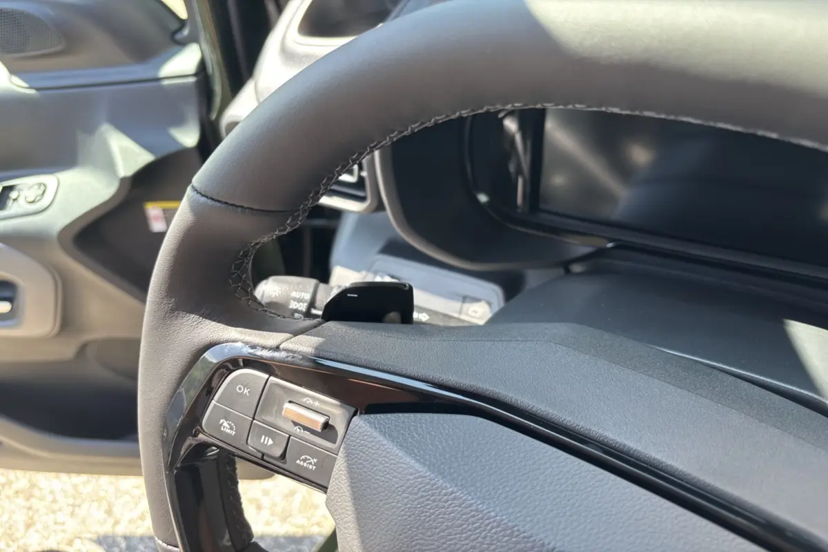 Gros plan sur le volant cuir multifonctions du Citroën Berlingo 2026, avec commandes intégrées et tableau de bord partiel.