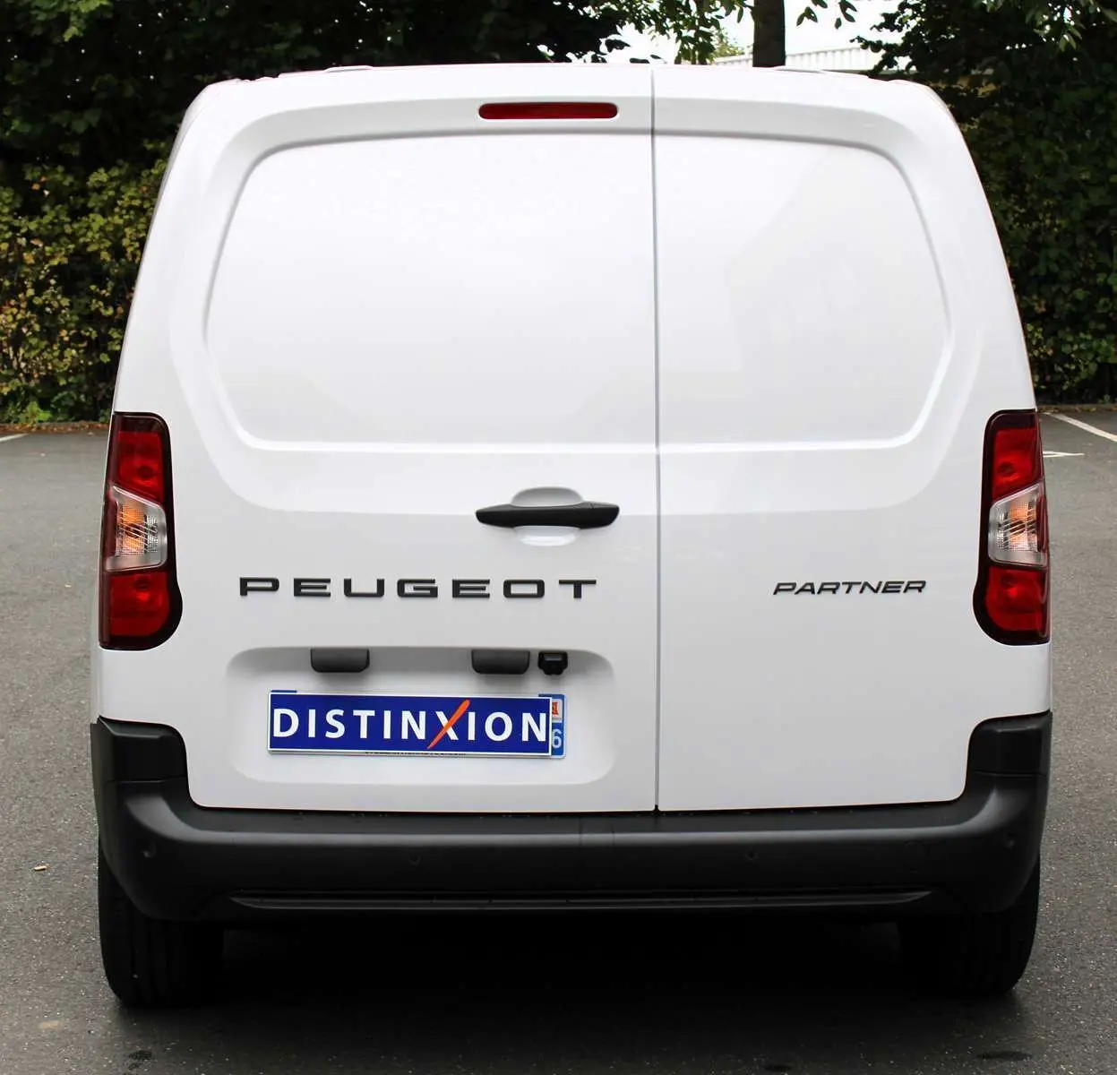 Vue arrière d'un Peugeot Partner Fourgon blanc 2025 avec logo et plaque d'immatriculation Distinxion visible.