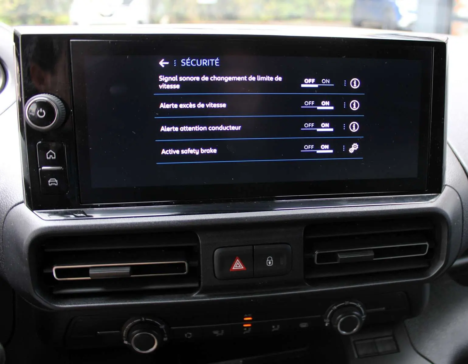 Écran tactile du tableau de bord du Peugeot Partner Fourgon 2025 affichant les options de sécurité activées.