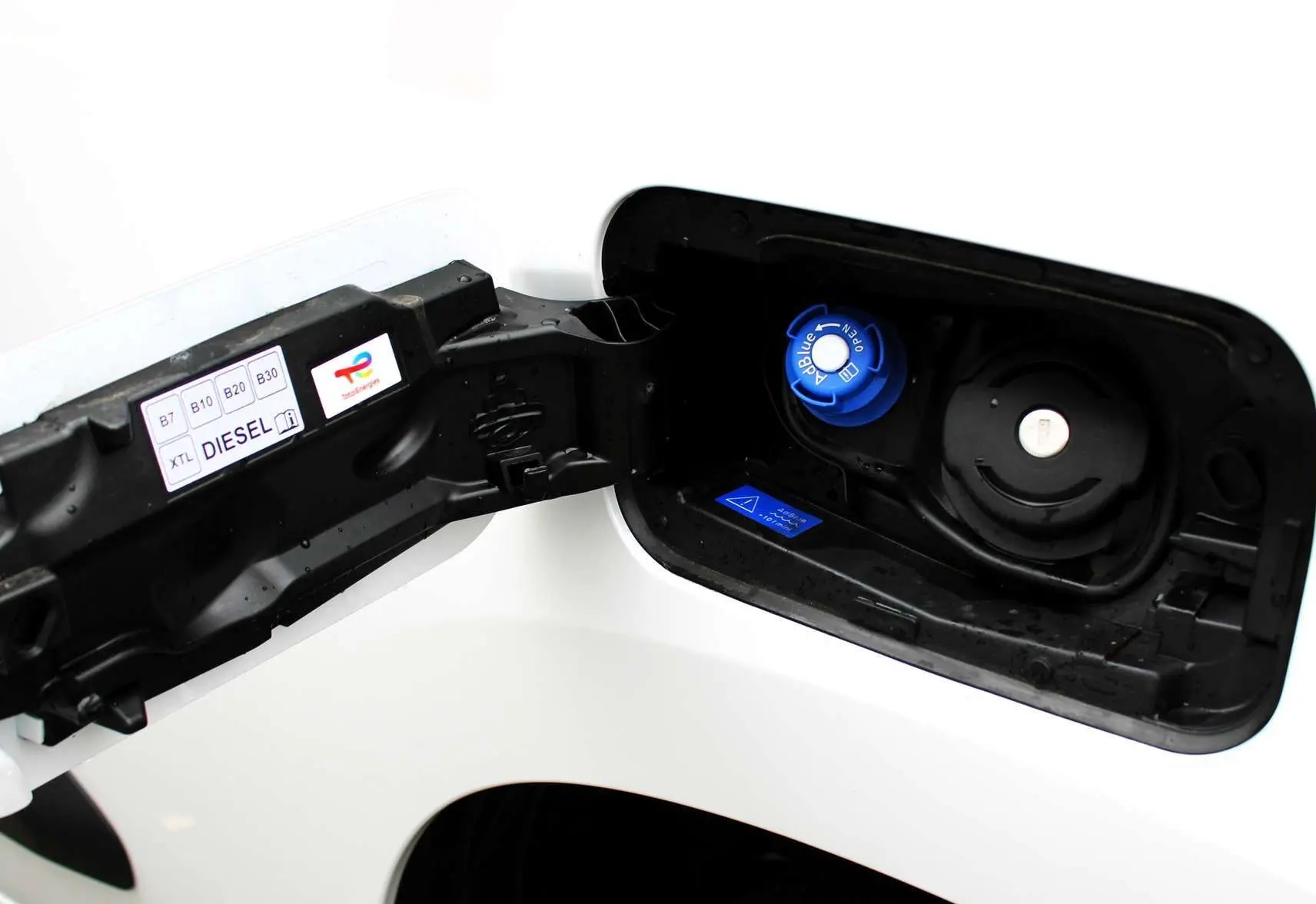 Bouchon de réservoir AdBlue bleu et bouchon diesel noir sur le côté gauche d'un Peugeot Partner Fourgon blanc 2025.