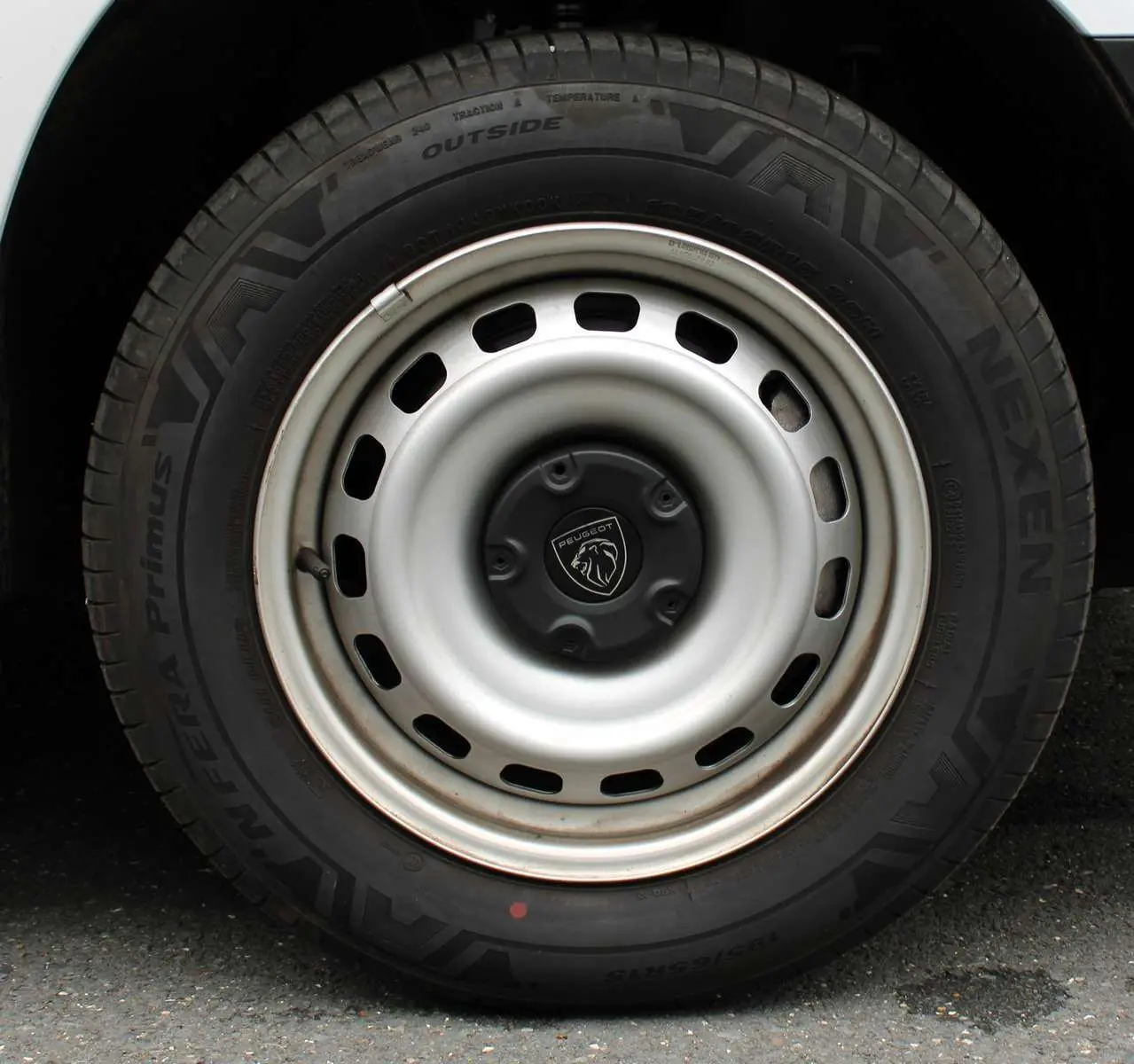 Gros plan sur la roue avant droite du Peugeot Partner Fourgon blanc 2025 avec jante acier et logo lion central.