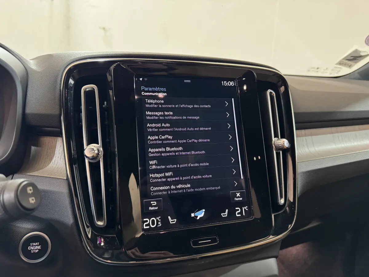 Vue intérieure centrée sur l'écran tactile 9 pouces du tableau de bord du Volvo XC40 noir, avec commandes climatisation visibles.