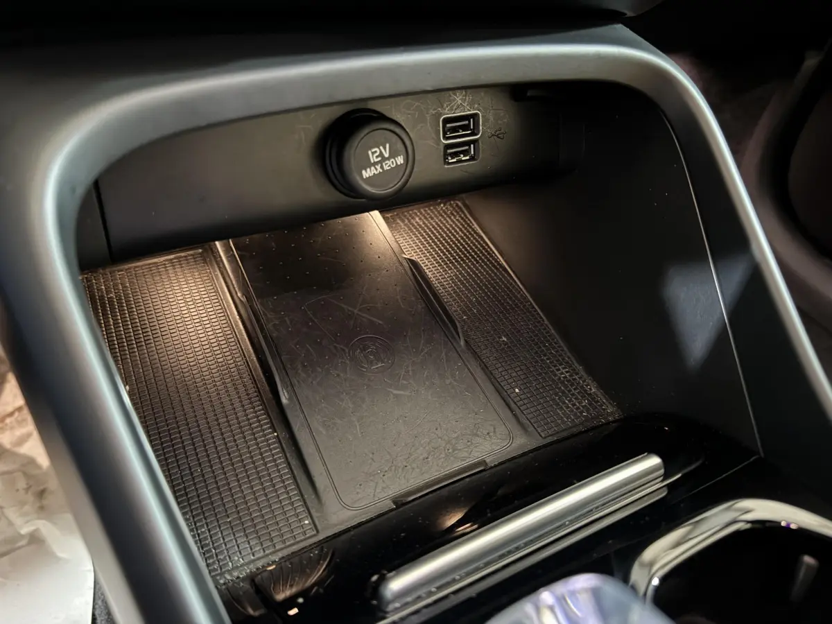 Vue rapprochée de la console centrale noire du Volvo XC40 Recharge T5 avec prise 12V et ports USB visibles.
