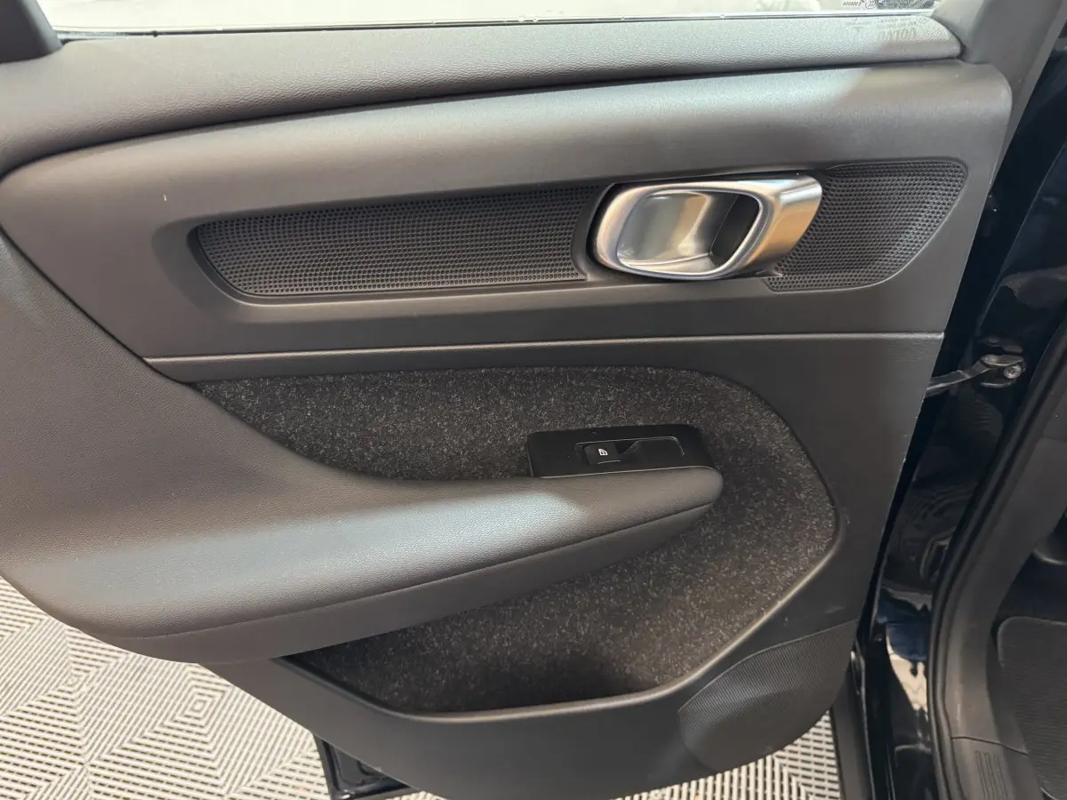 Vue intérieure du panneau de porte avant droit noir du Volvo XC40 Recharge T5 2021 avec poignée alu et commande de verrouillage.