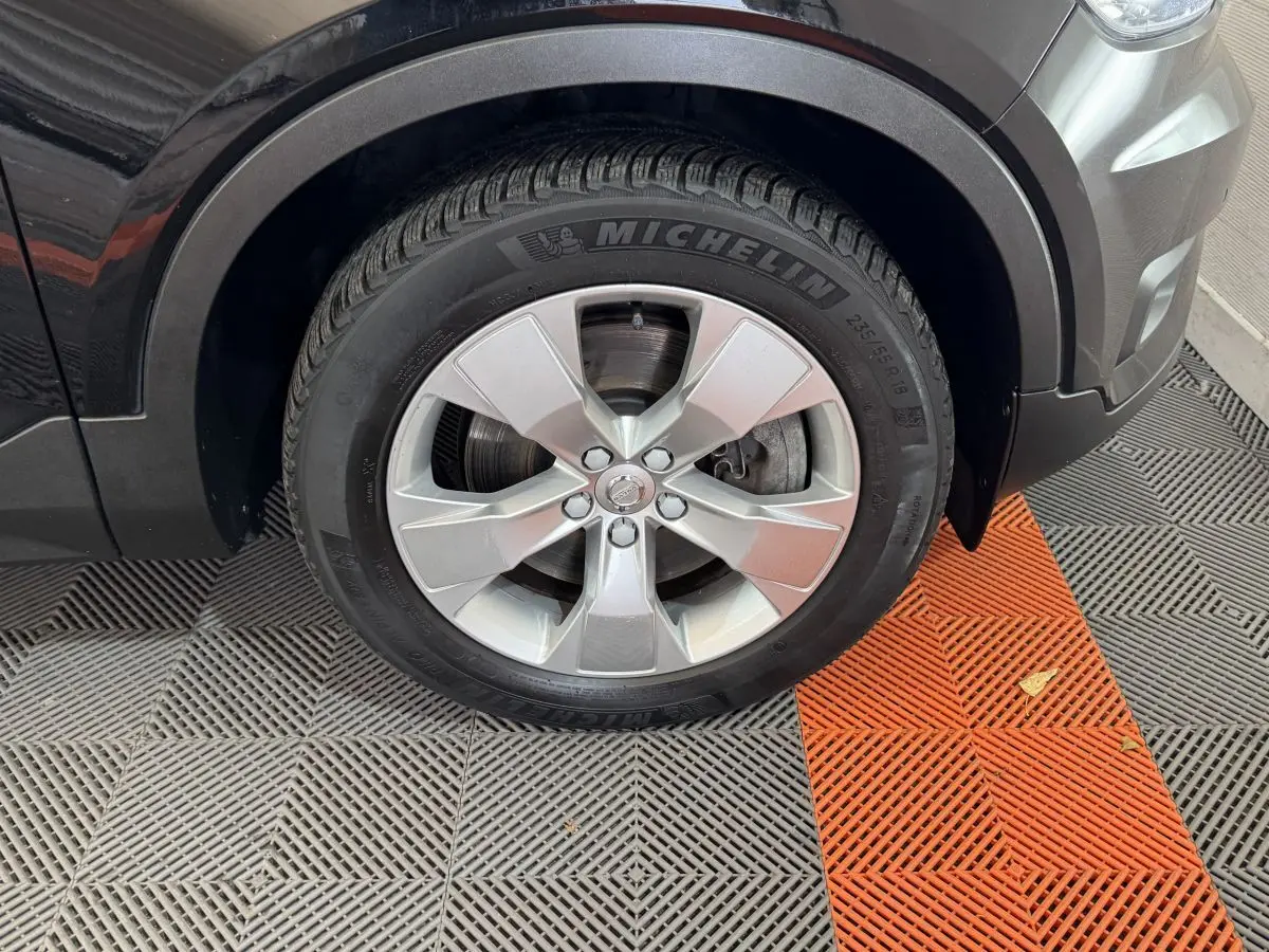 Gros plan sur la roue avant gauche noire du Volvo XC40 Recharge T5 avec jante argentée et pneu Michelin.