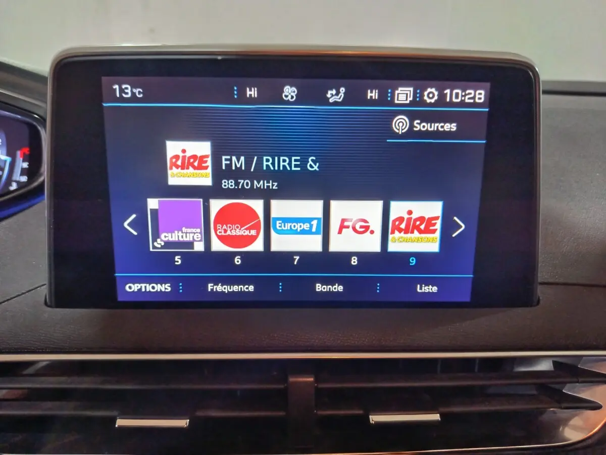 Écran tactile central affichant les radios FM dans l’habitacle du Peugeot 3008 marron, vue de face rapprochée.