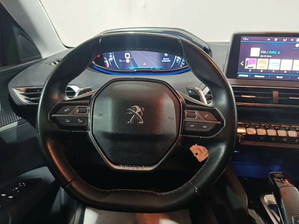 Vue intérieure centrée sur le volant cuir noir du Peugeot 3008 2019 avec tableau de bord digital et écran tactile.