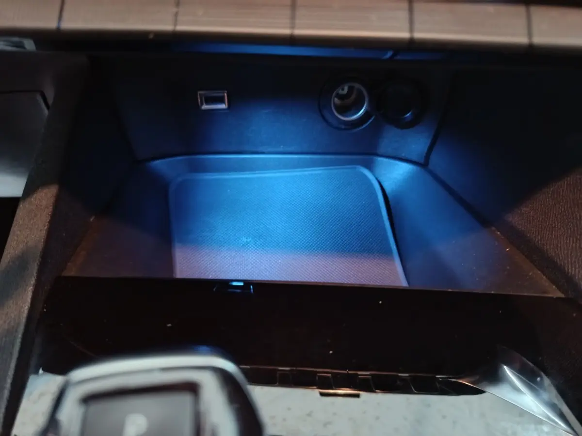 Gros plan sur la console centrale du Peugeot 3008 marron, montrant prise USB et allume-cigare avec éclairage bleu.