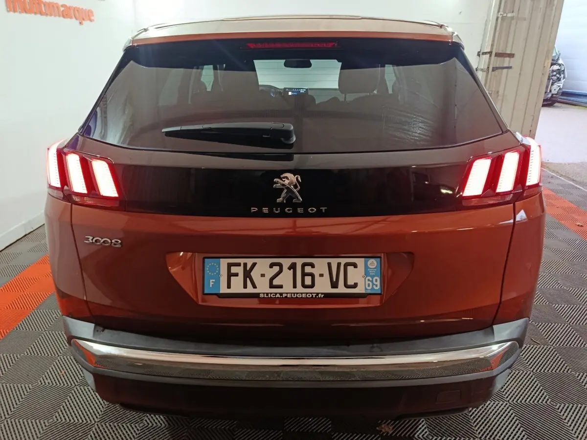 Vue arrière d’un Peugeot 3008 marron avec feux arrière LED allumés et plaque d’immatriculation visible.