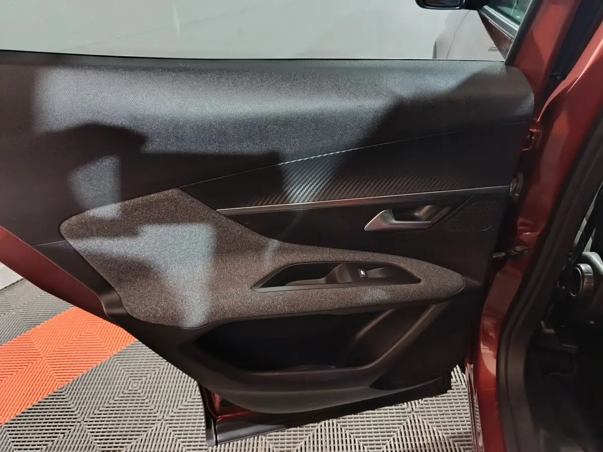 Vue intérieure côté gauche de la porte arrière marron du Peugeot 3008 avec garniture noire et insert gris texturé.