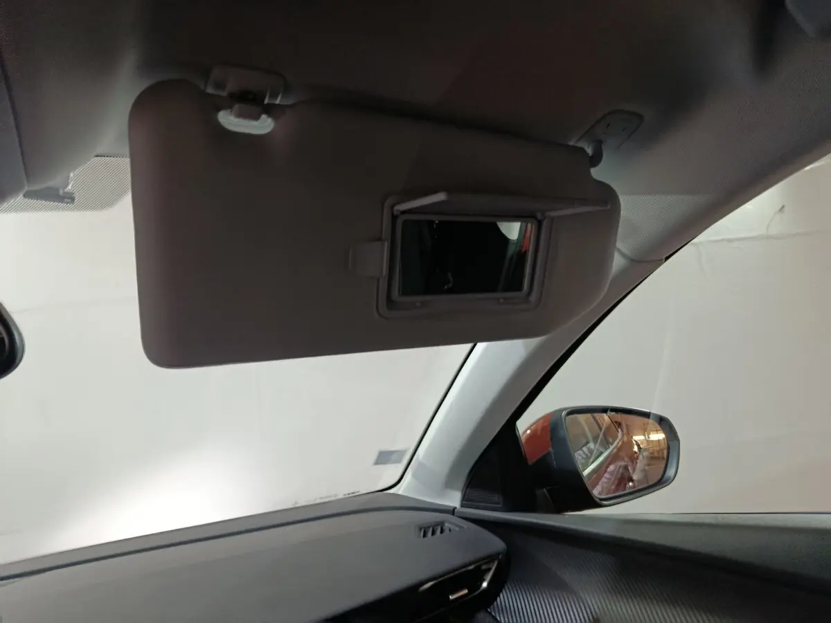 Vue intérieure côté passager du Peugeot 3008 2019, montrant le pare-soleil avec miroir et le rétroviseur extérieur.