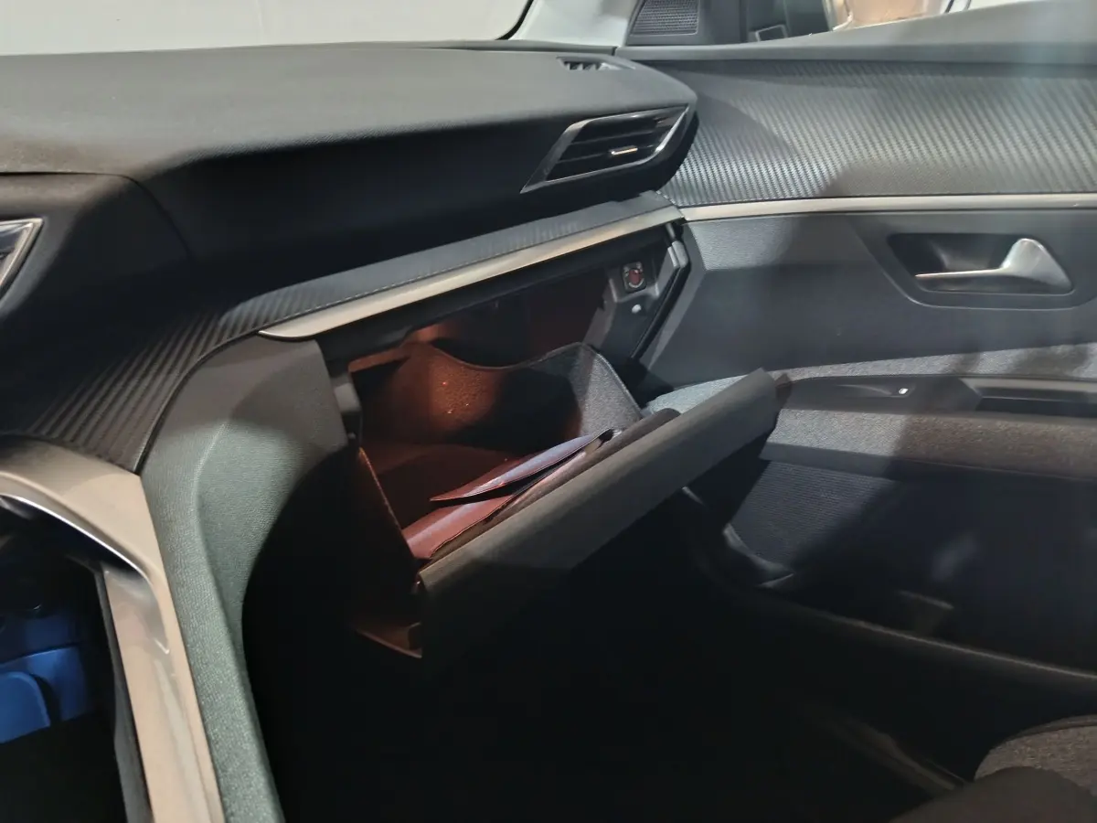Intérieur Peugeot 3008 2019 marron, vue de la boîte à gants ouverte côté passager avec tableau de bord texturé.
