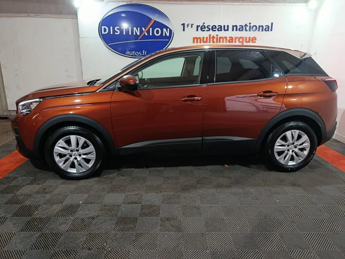 Vue de profil côté gauche d'un Peugeot 3008 marron 2019 garé en intérieur avec jantes argentées et protections noires.