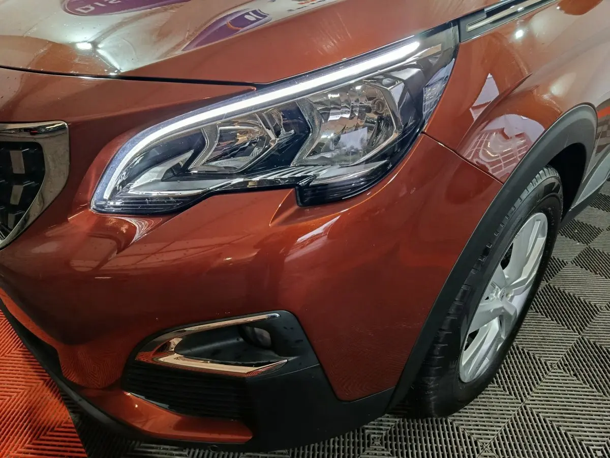 Gros plan sur l'avant droit marron du Peugeot 3008 2019, mettant en valeur le phare et la calandre chromée.
