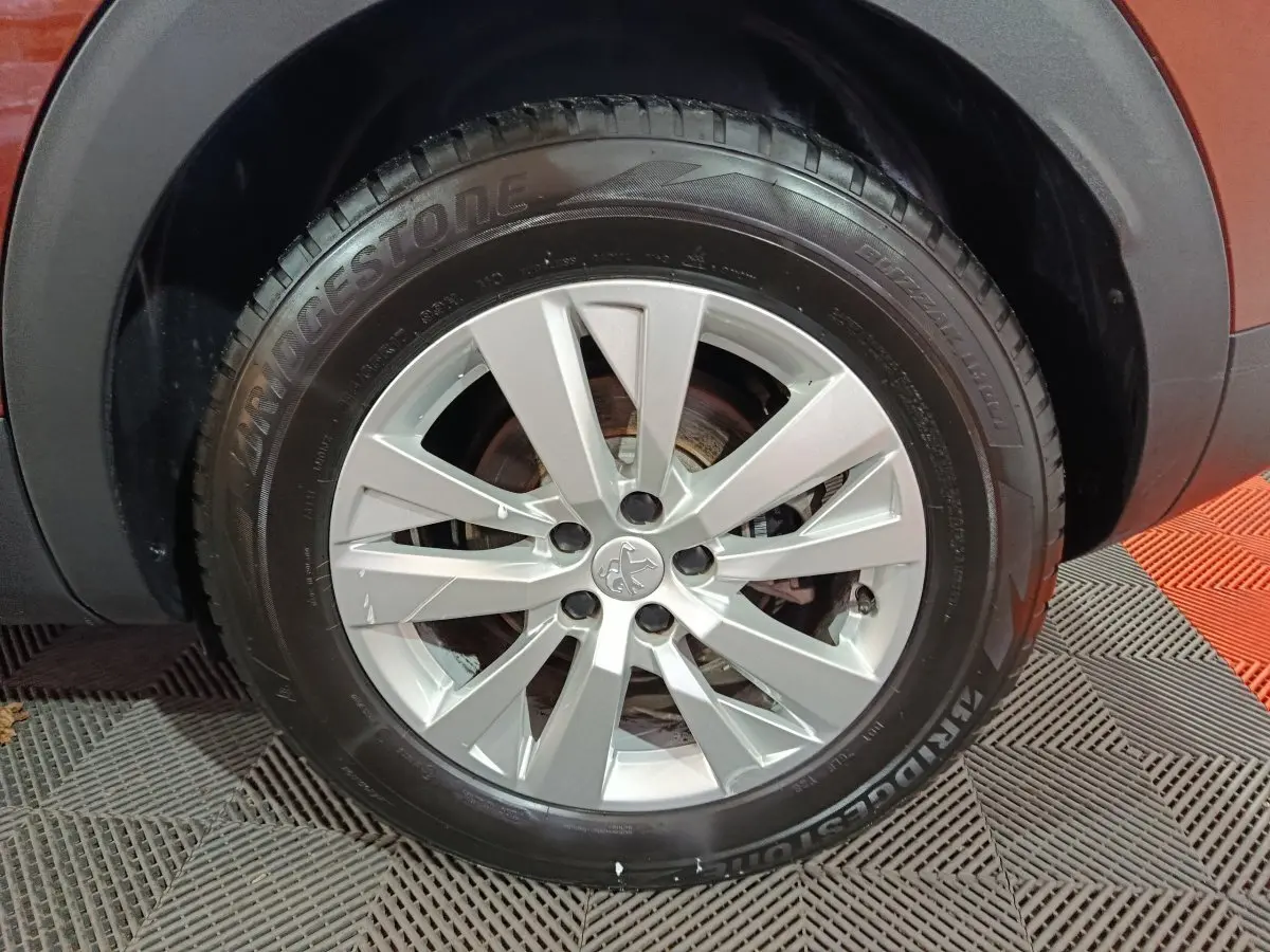 Gros plan sur la roue avant droite du Peugeot 3008 marron, mettant en valeur la jante argentée et le pneu Bridgestone.