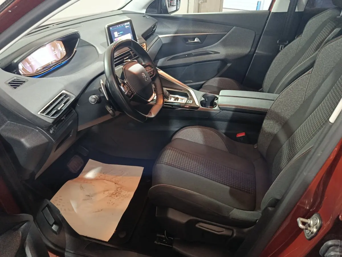 Vue intérieure côté conducteur du Peugeot 3008 2019, montrant le tableau de bord et les sièges en tissu gris.