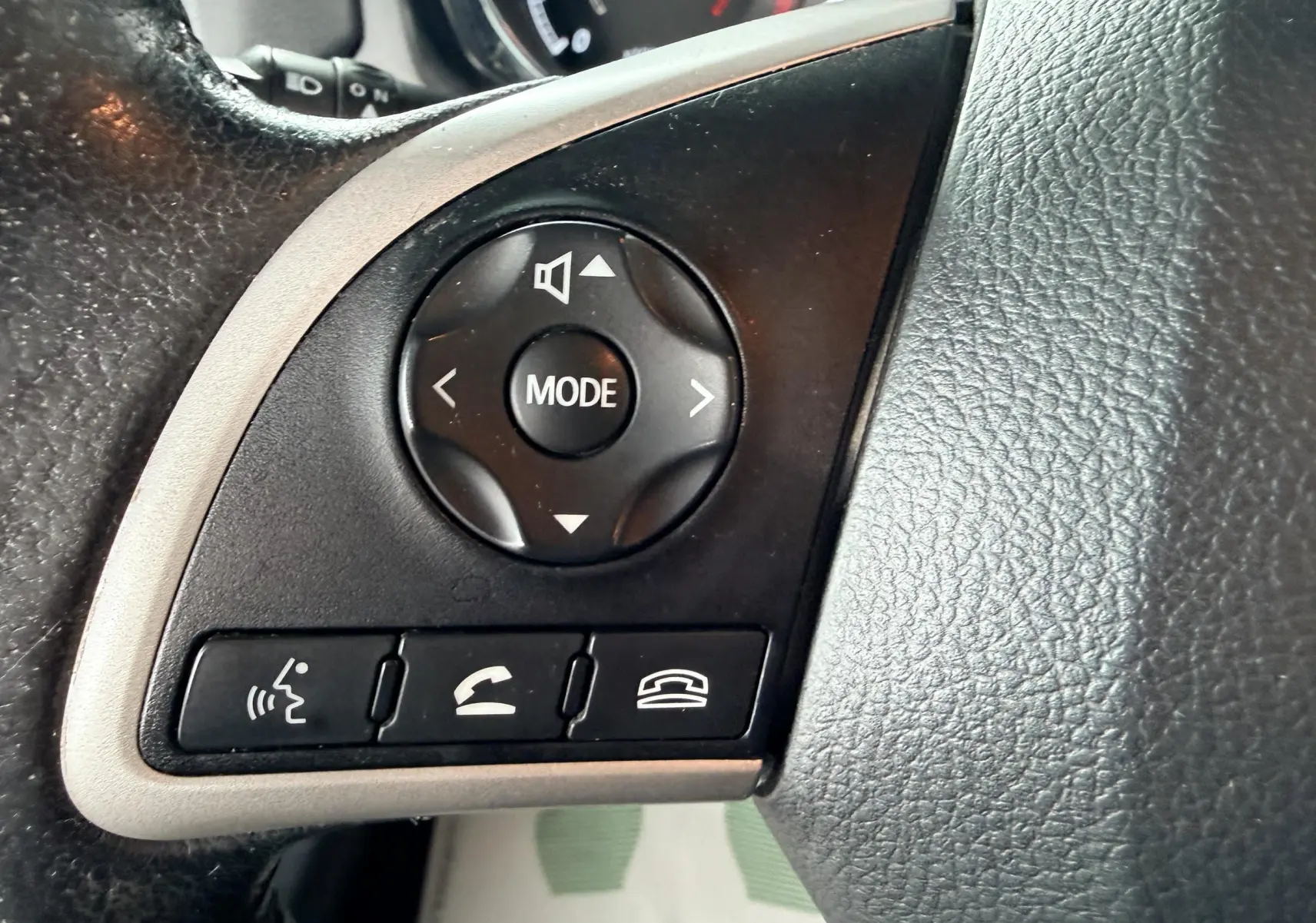 Gros plan sur les commandes multifonctions noires du volant en cuir noir du Mitsubishi ASX gris, version 2015.