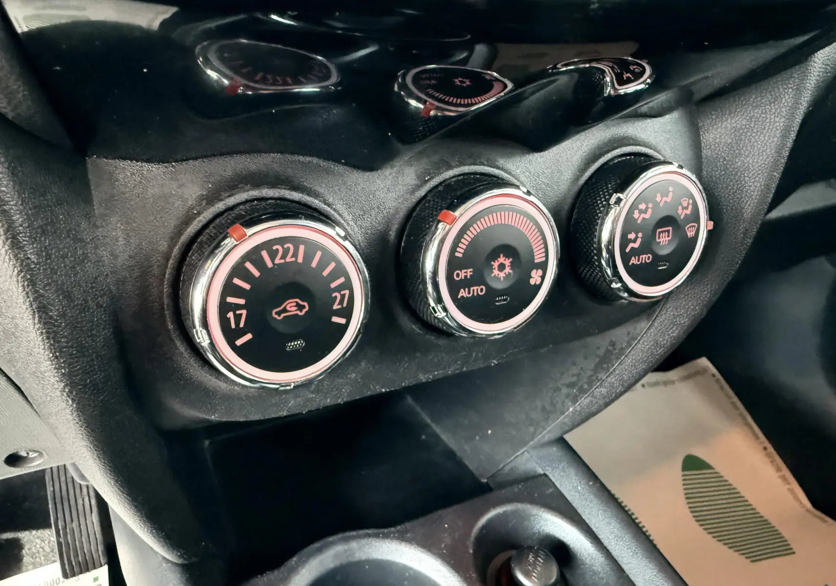 Gros plan sur les commandes de climatisation du Mitsubishi ASX 2015, avec réglages circulaires rétroéclairés en rouge.