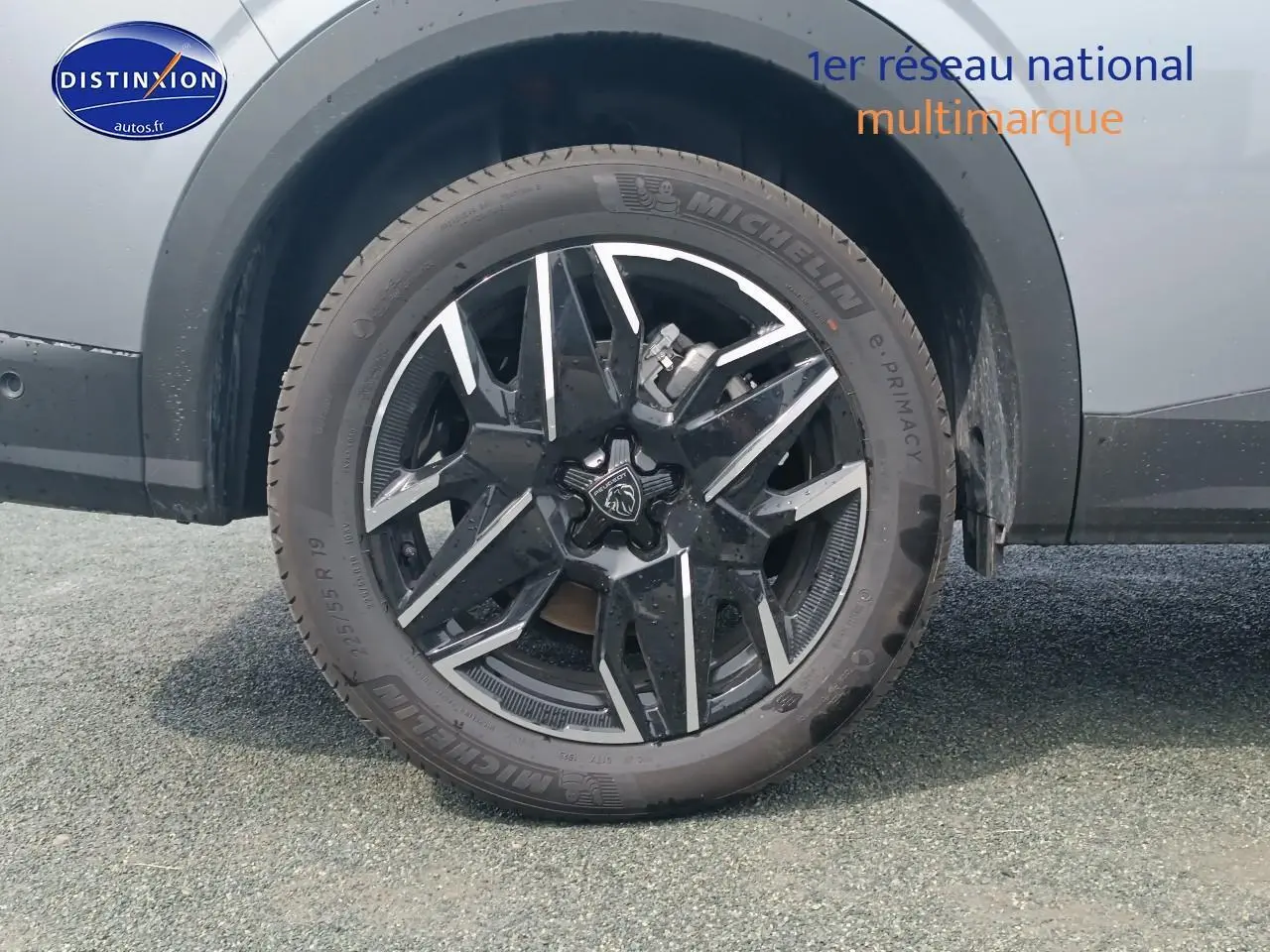 Gros plan sur la roue arrière droite du Peugeot 5008 gris artense, mettant en valeur la jante alu noire et argentée.