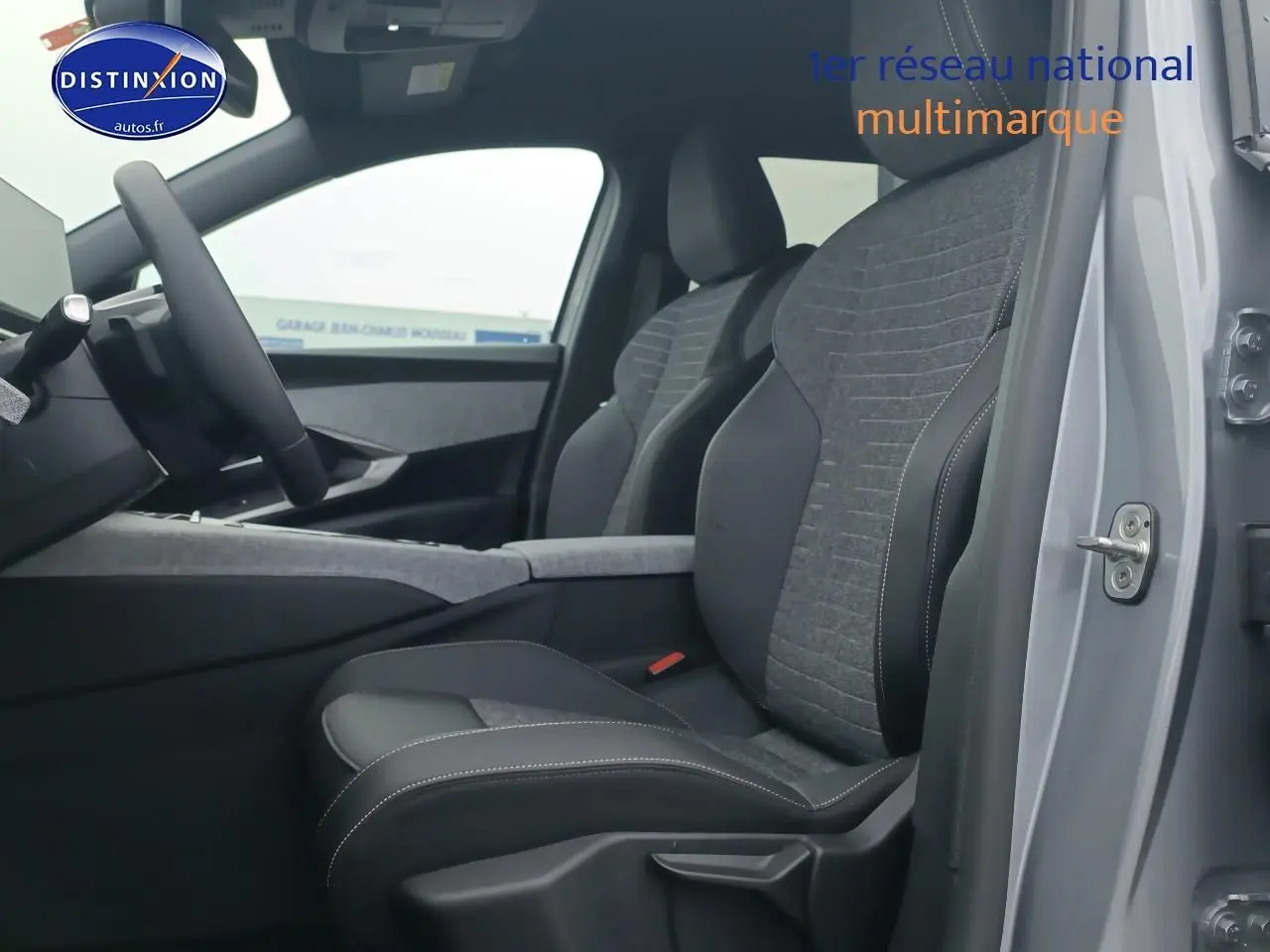 Vue intérieure côté conducteur du Peugeot 5008 gris artense, mettant en valeur les sièges tissu et cuir bicolores.
