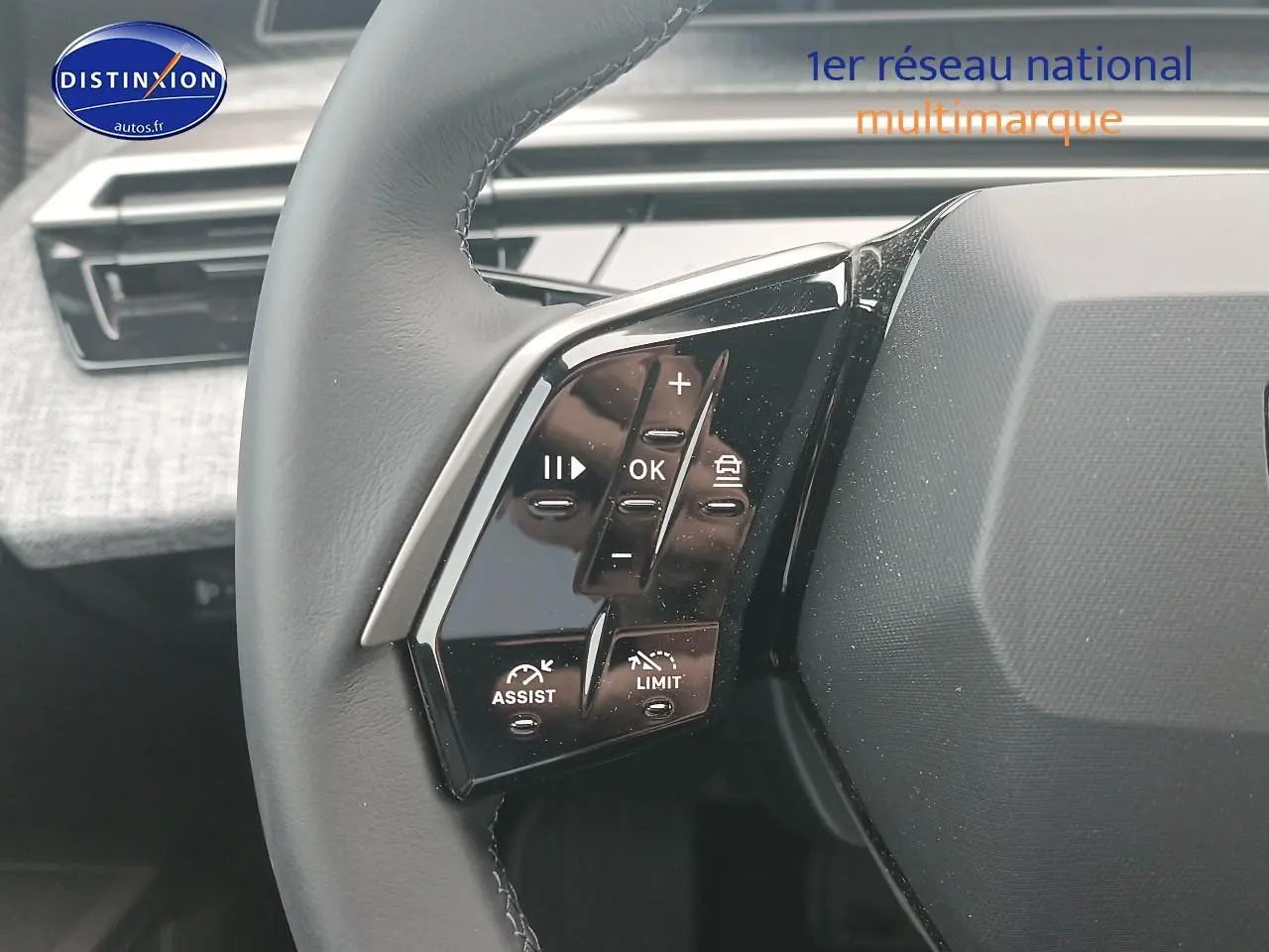 Gros plan sur le volant cuir multifonction du Peugeot 5008 Hybrid 145 allure e-dcs6 avec commandes intégrées.