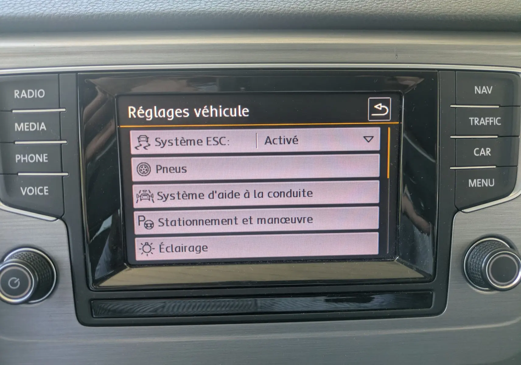 Écran central du tableau de bord d'une Volkswagen Golf Sportsvan 2014 affichant les réglages véhicule.