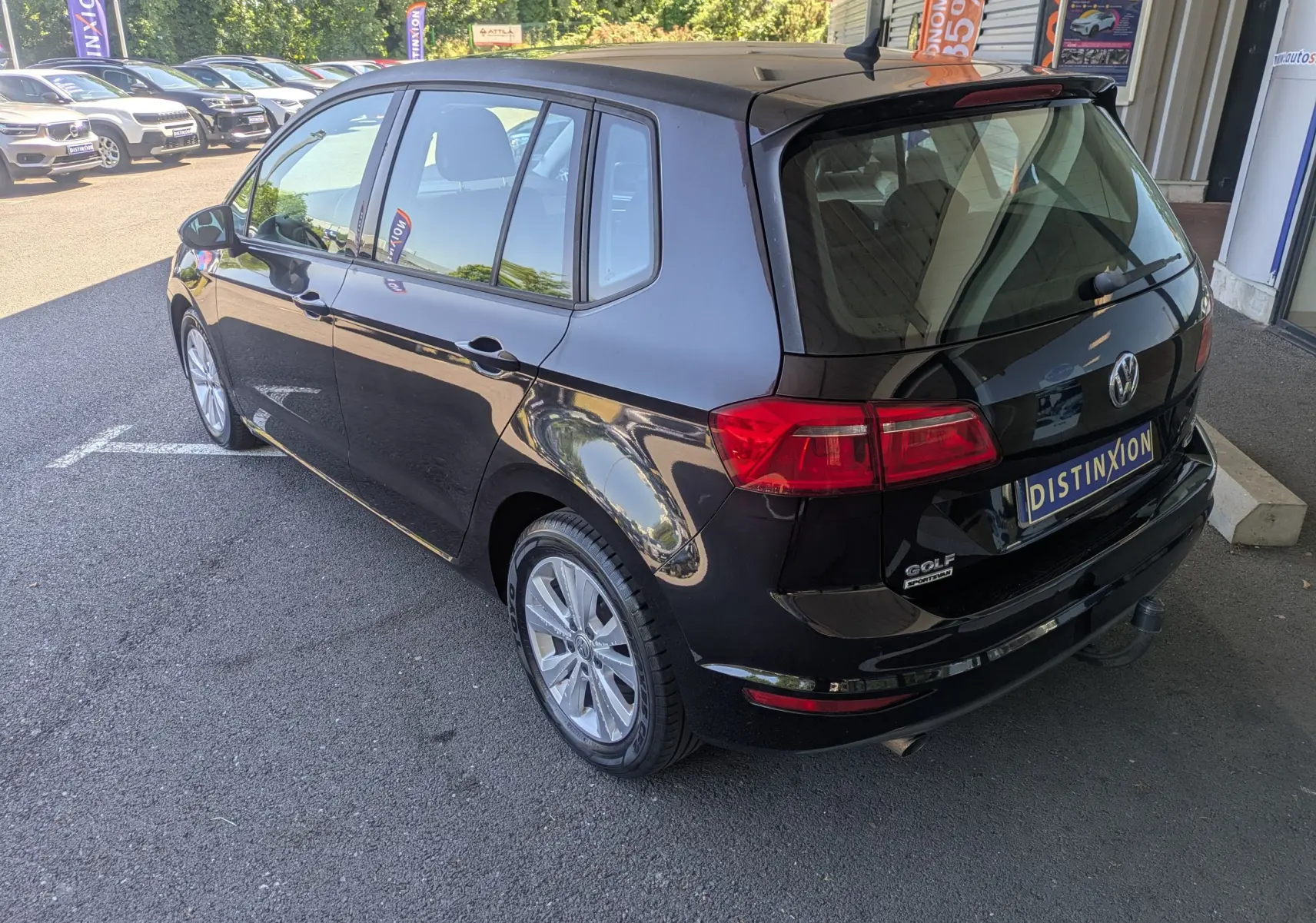 Vue 3/4 arrière droite d'une Volkswagen Golf Sportsvan noire de 2014, avec hayon fermé et jantes alliage visibles.