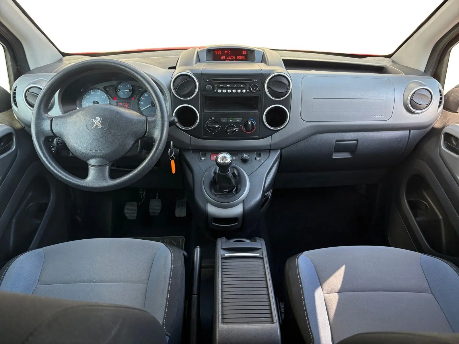 Vue intérieure avant du tableau de bord et volant noir du Peugeot Partner Tepee 1.6 BlueHDi 2016 avec boîte manuelle.