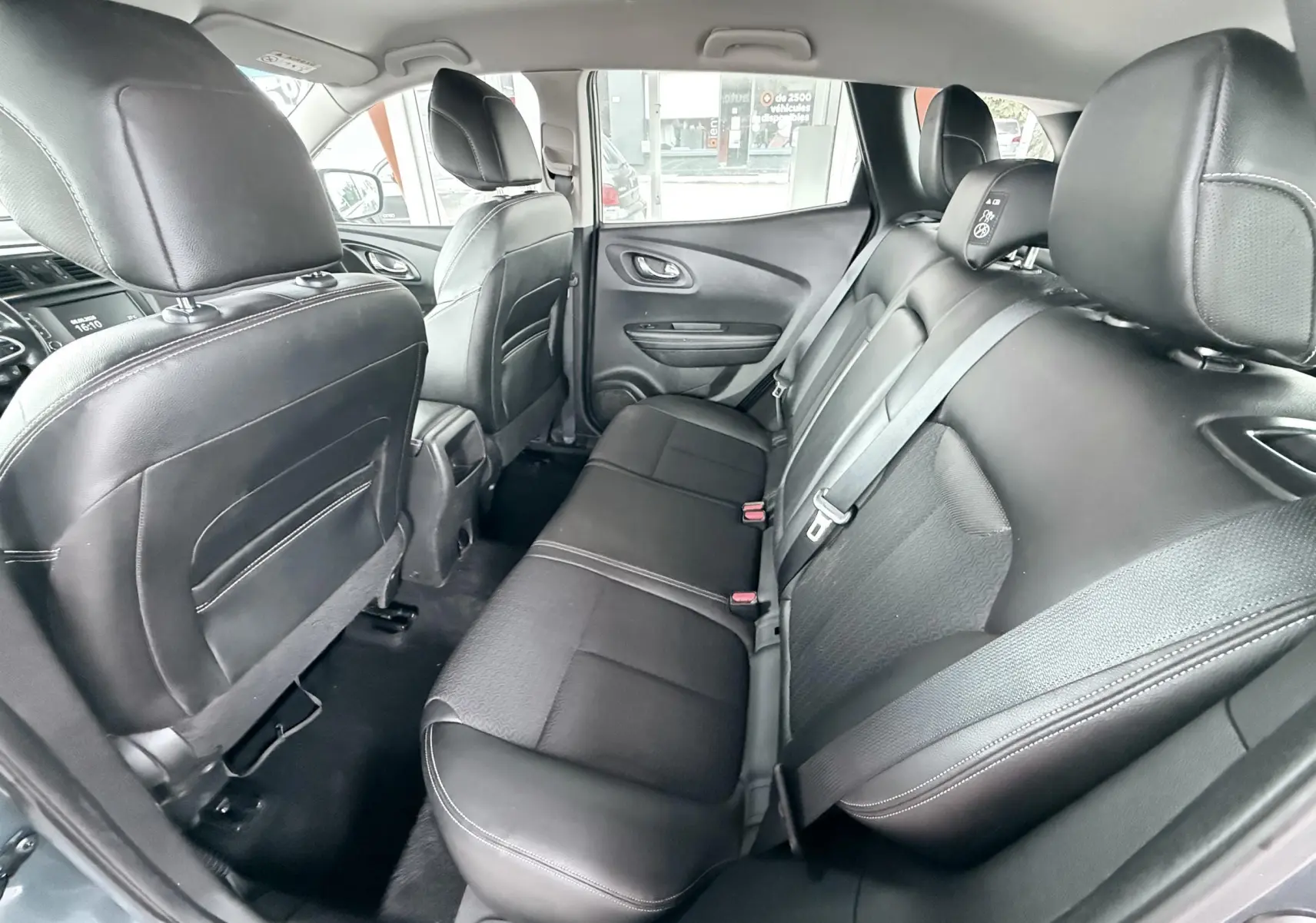 Vue intérieure arrière du Renault Kadjar 2016, sièges en cuir noir avec ceinture de sécurité visible côté droit.