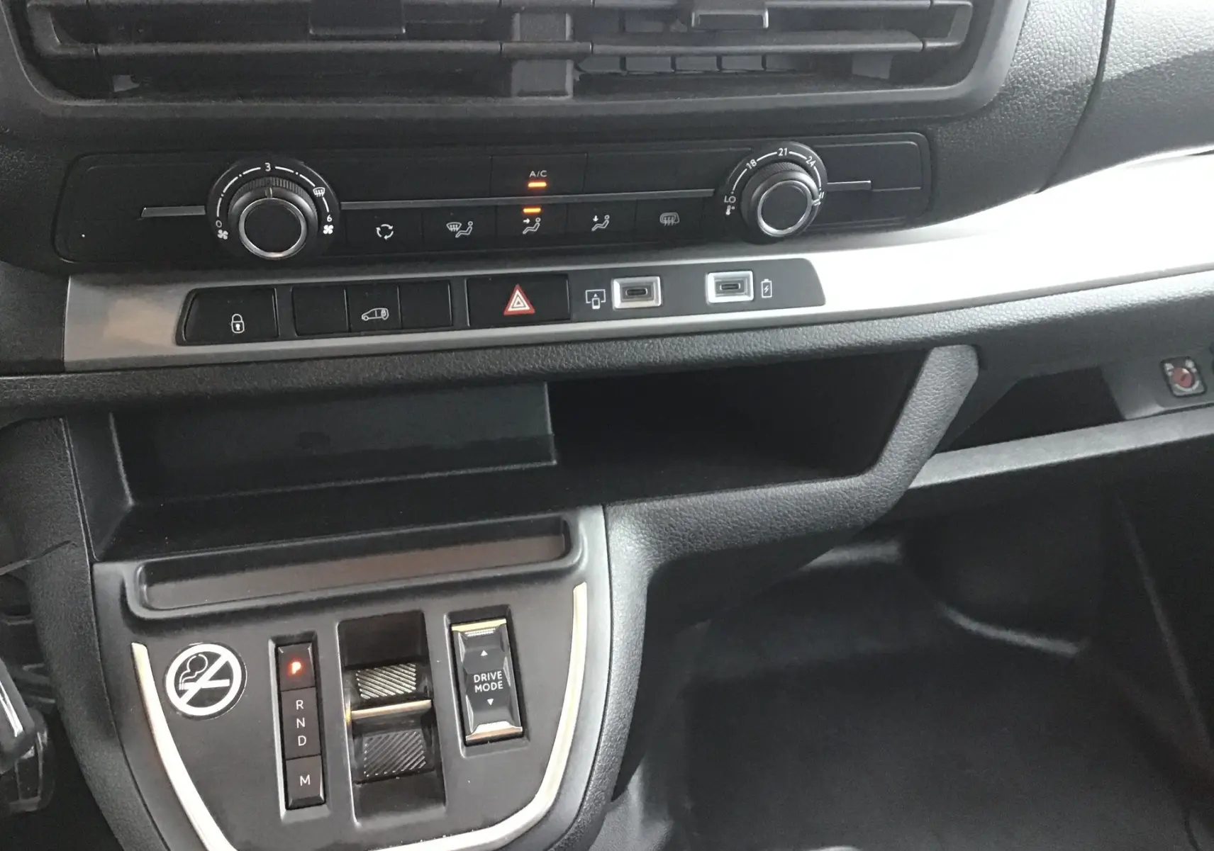Vue rapprochée du tableau de bord noir du Fiat Scudo Fourgon 2024, montrant commandes climatisation et levier de boîte automatique.