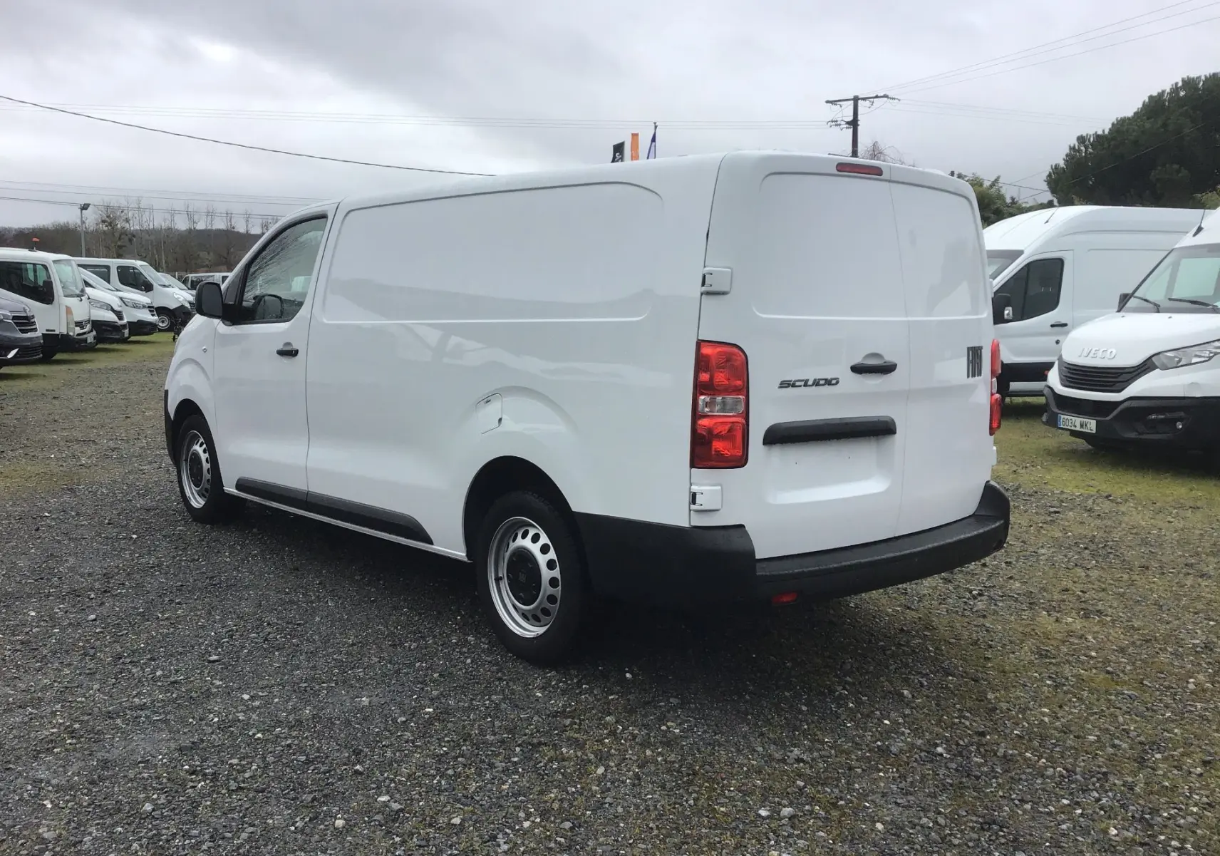 Fiat Scudo Fourgon blanc vu en 3/4 arrière droit, avec porte latérale coulissante et pare-chocs noirs robustes.