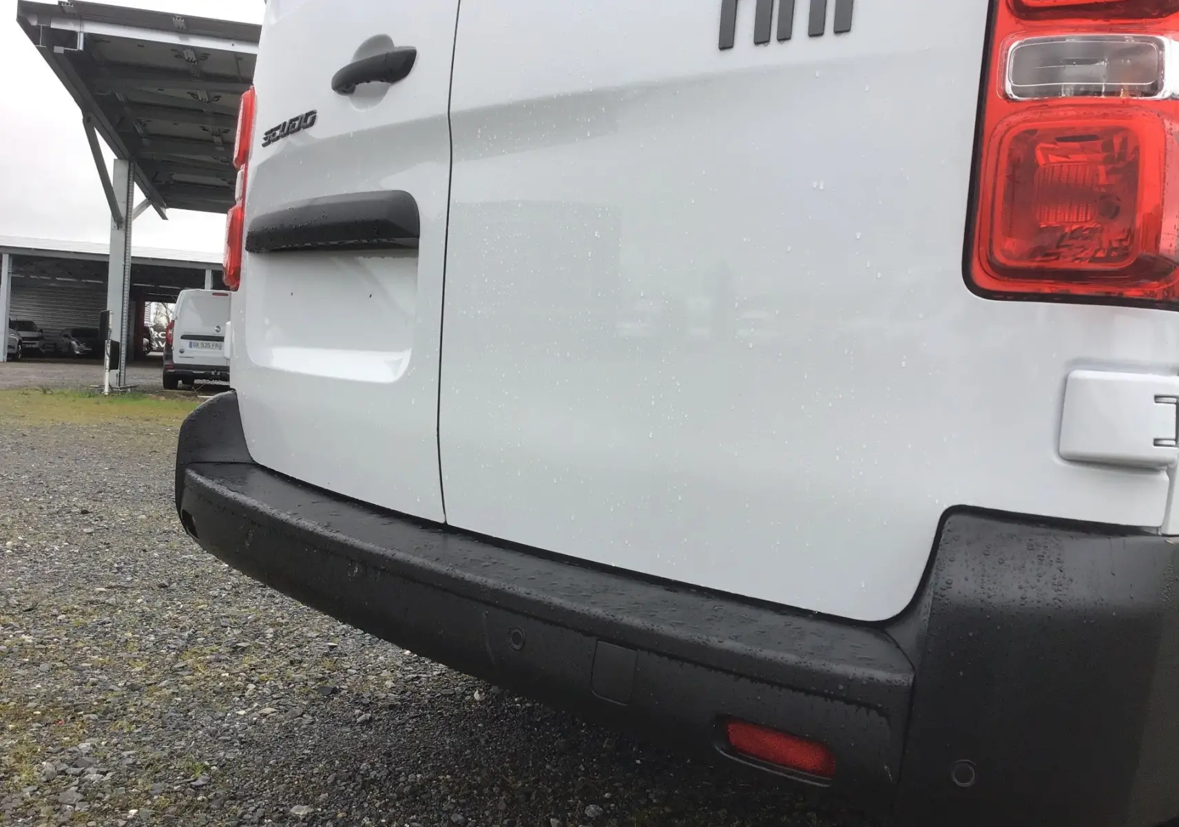 Vue rapprochée arrière droite du fourgon blanc Fiat Scudo 2024 avec pare-chocs noir et feux arrière visibles.