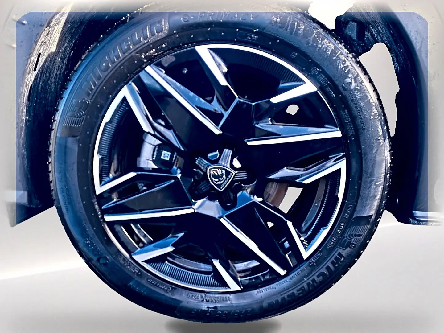 Gros plan sur la jante alu noire et argentée du côté droit d’un Peugeot 5008 Hybrid 145 GT e-dcs6 noir.