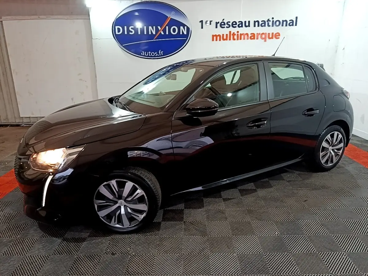 Peugeot 208 noire vue de profil côté gauche, phare avant allumé, dans un showroom intérieur.