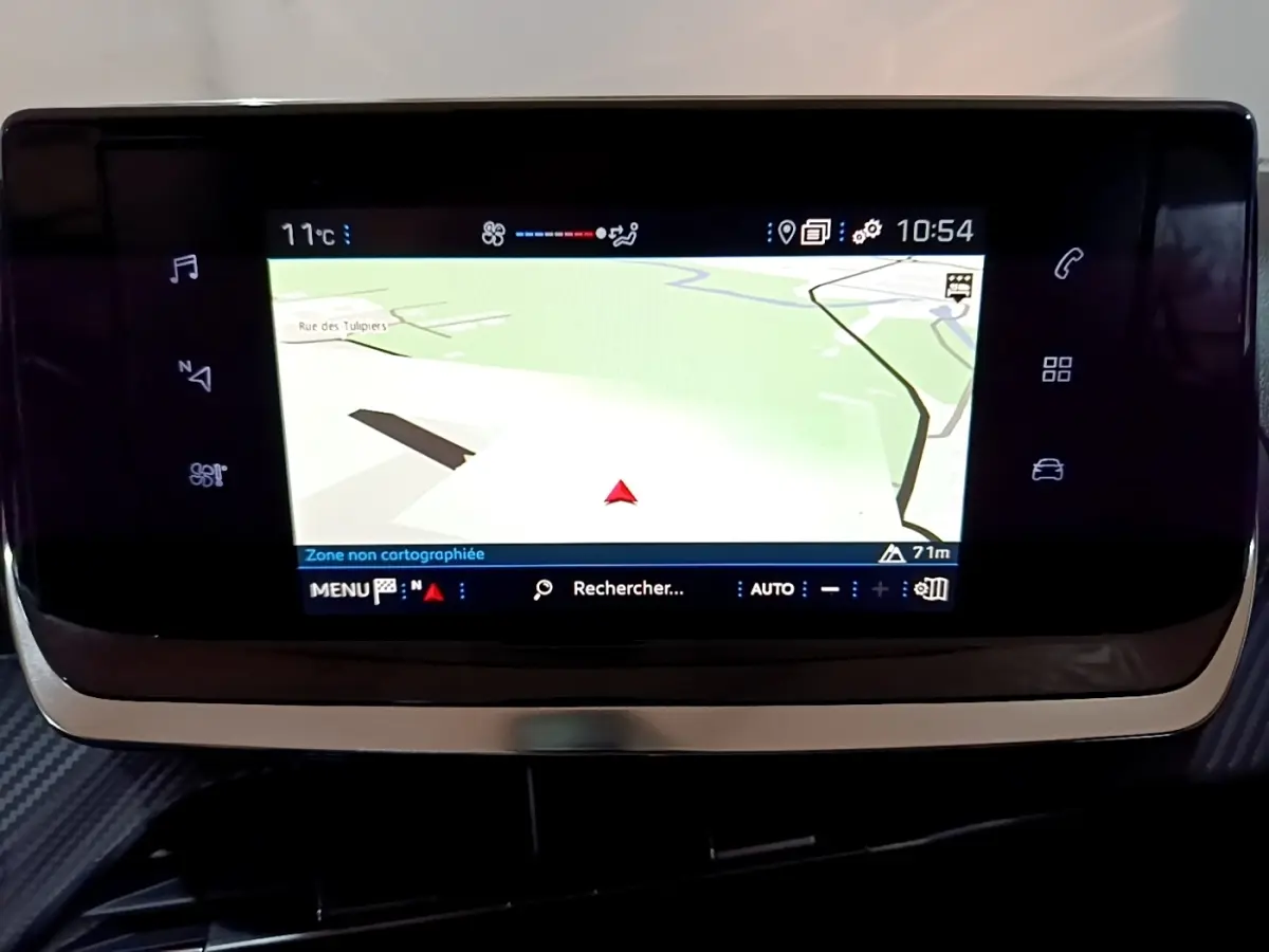 Écran tactile central de navigation de la Peugeot 208 noire, vue rapprochée du tableau de bord intérieur.