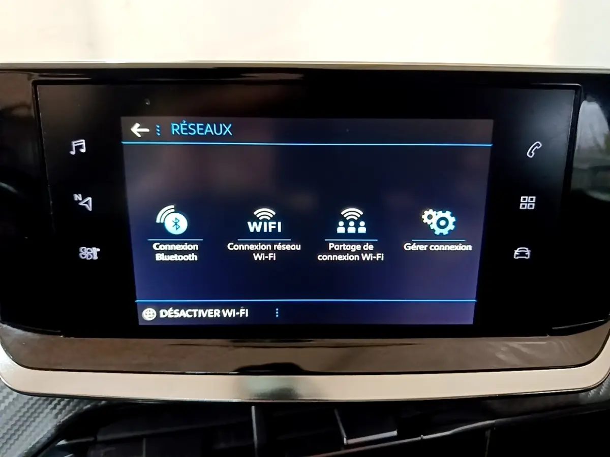 Écran tactile central affichant les options réseau dans l’habitacle d’une Peugeot 208 noire de 2020.