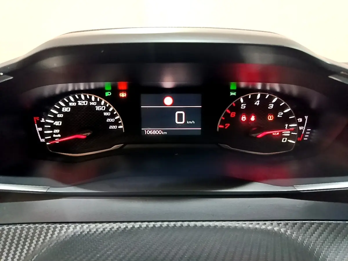 Vue rapprochée du tableau de bord numérique de la Peugeot 208 noir, affichant la vitesse à 0 km/h et le compteur kilométrique.