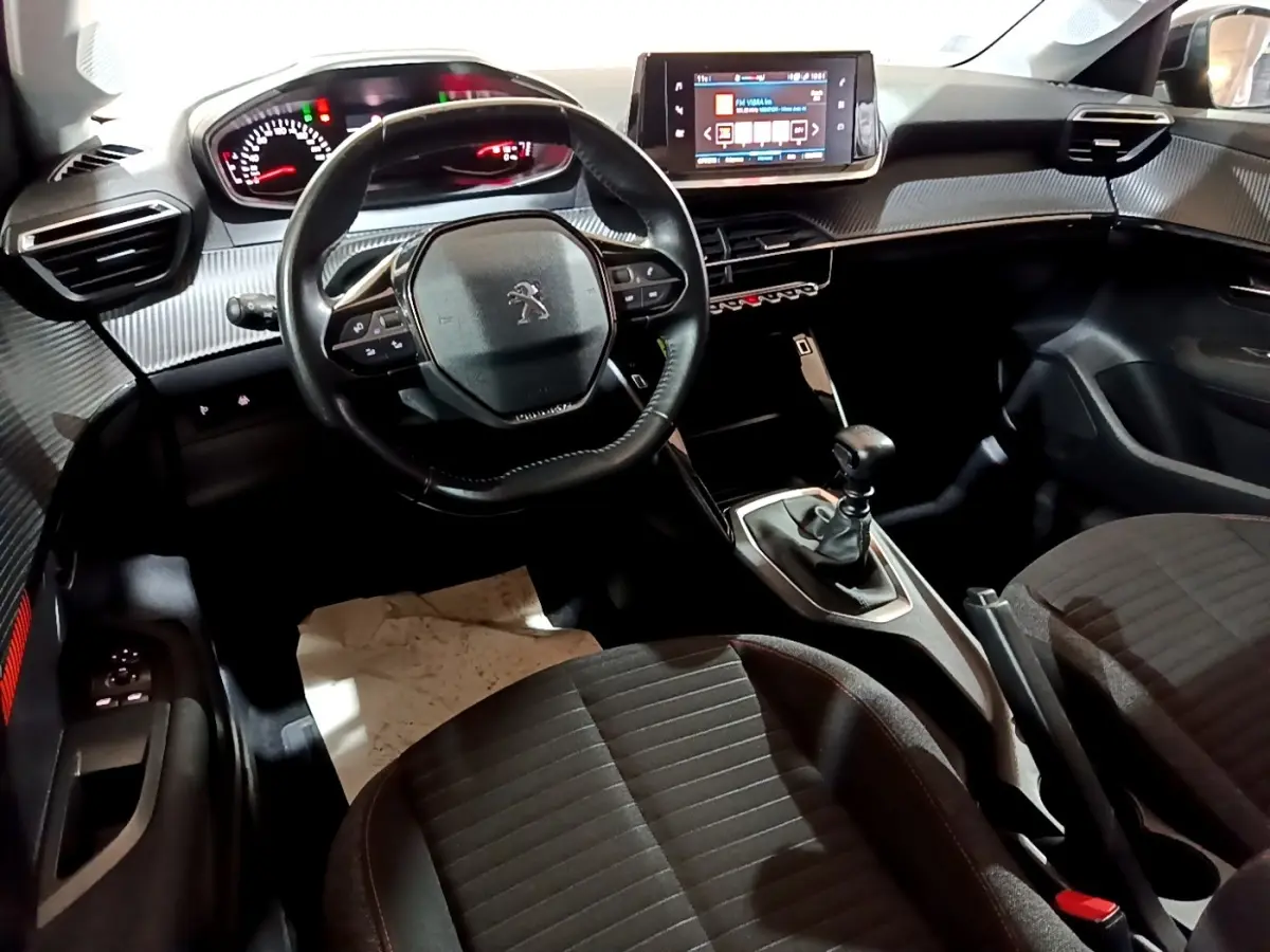 Intérieur de la Peugeot 208 2020 vue de face, volant cuir, tableau de bord avec écran tactile et boîte manuelle.