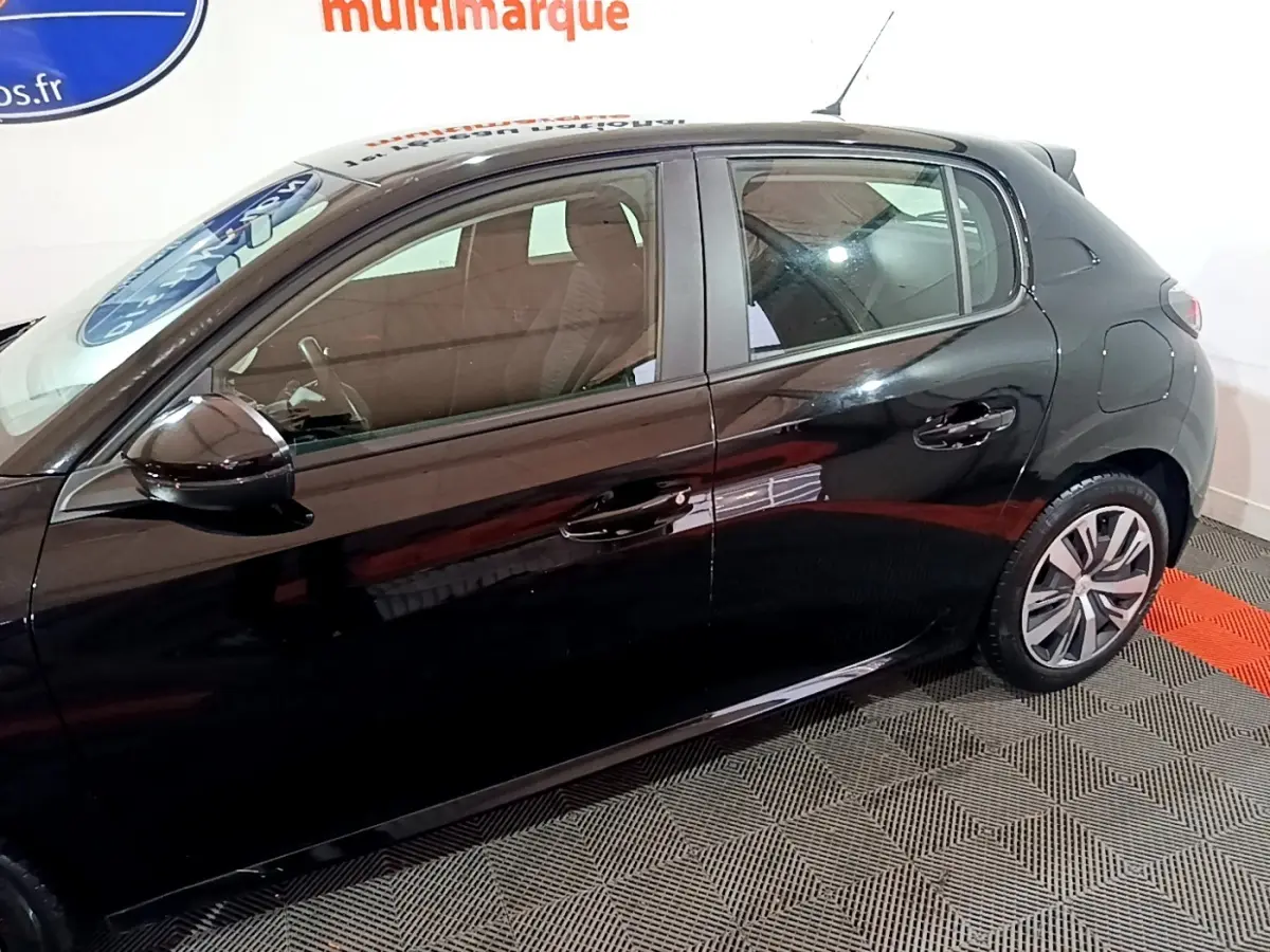 Profil côté gauche d'une Peugeot 208 noire de 2020, avec jantes alliage et rétroviseurs noirs brillants.