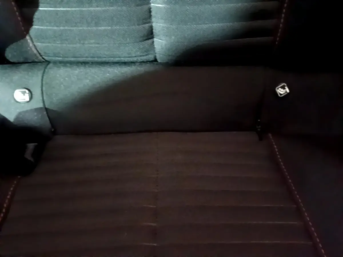 Vue rapprochée de la banquette arrière noire du Peugeot 208 avec logos Isofix visibles sur les côtés.