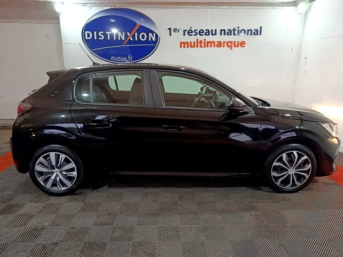 Profil côté gauche d'une Peugeot 208 noire de 2020, version BlueHDi 100 S&S Active Business, en intérieur showroom.
