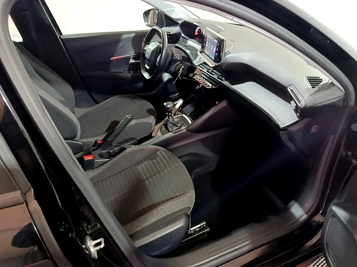 Intérieur de la Peugeot 208 noir vue côté conducteur, avec tableau de bord moderne et écran tactile central.