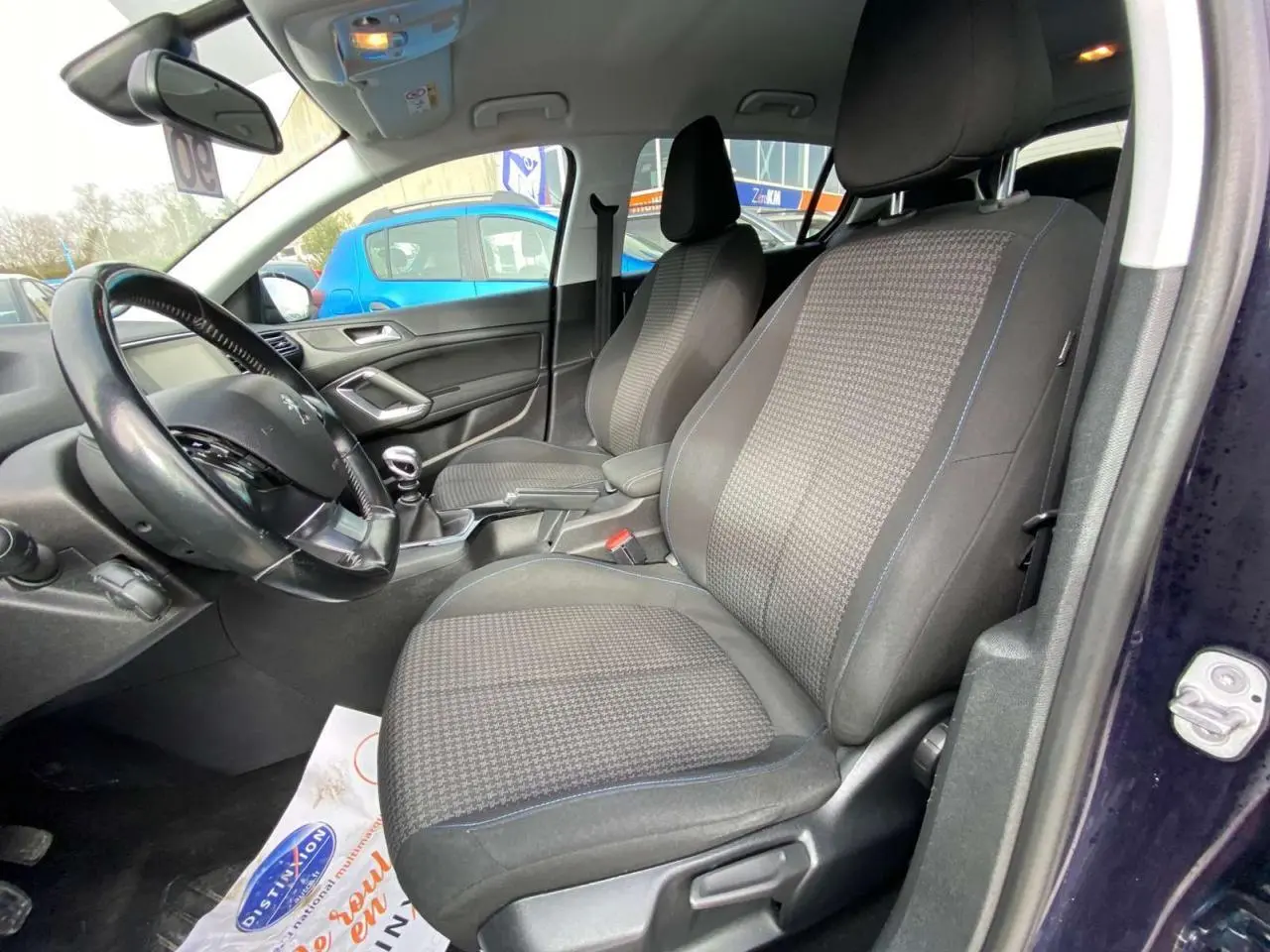 Vue intérieure côté conducteur du Peugeot 308 2018 bleu foncé, montrant les sièges avant et le volant avec boîte manuelle.