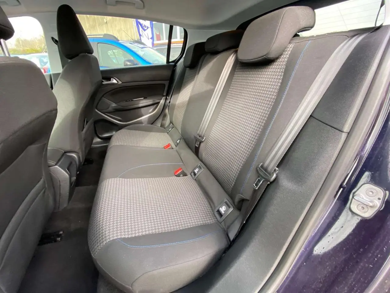 Vue intérieure côté droit de la banquette arrière grise à motifs avec surpiqûres bleues d'une Peugeot 308 Dark Blue 2018.