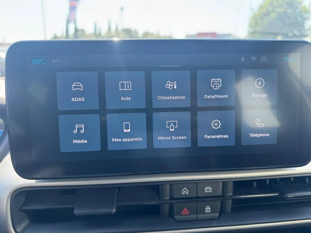 Écran tactile central du Jeep Avenger blanc 2025 montrant les options climatisation, média et paramètres.