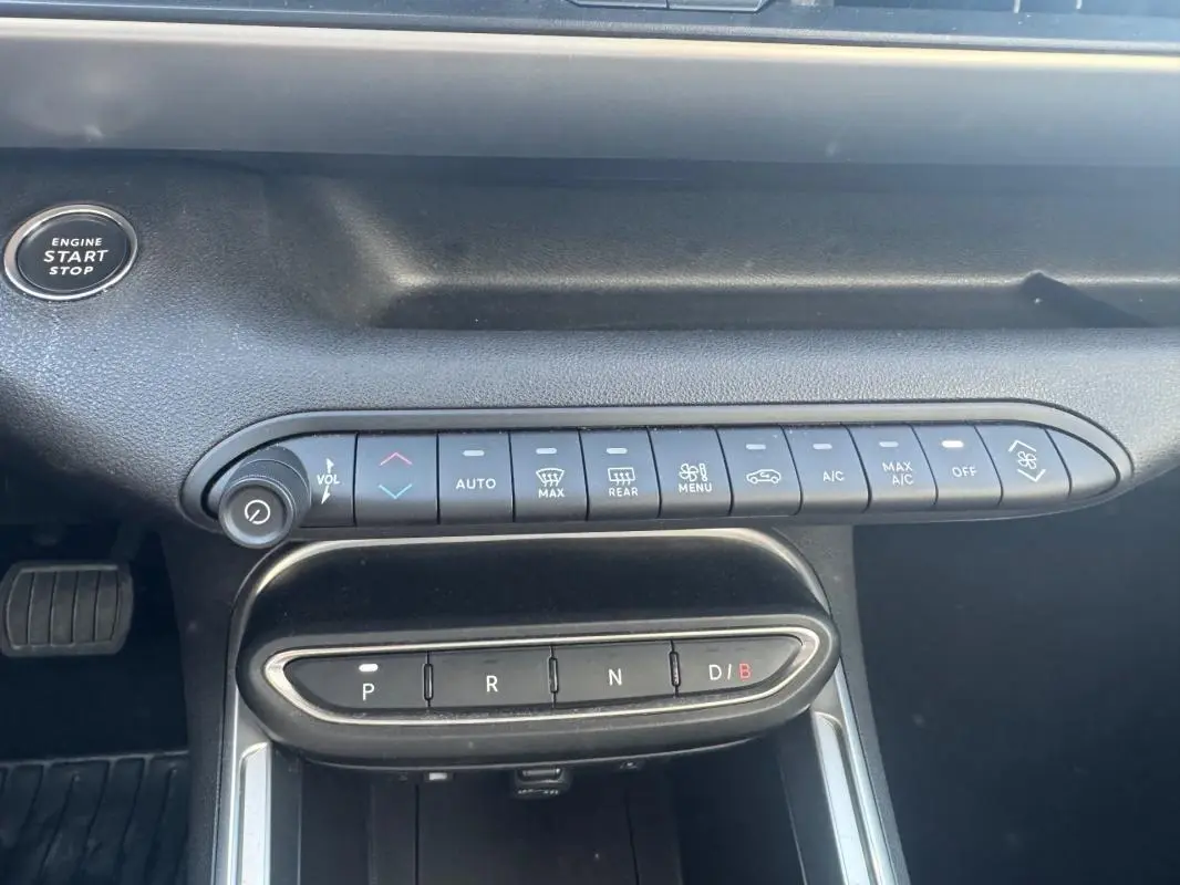 Vue rapprochée de la console centrale du Jeep Avenger électrique 2025, avec commandes climatisation et boîte auto.